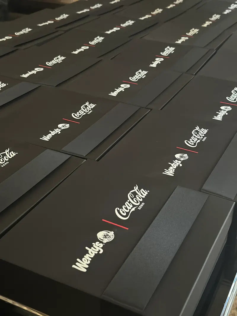 Cajas negras con logos de Wendy's y Coca-Cola