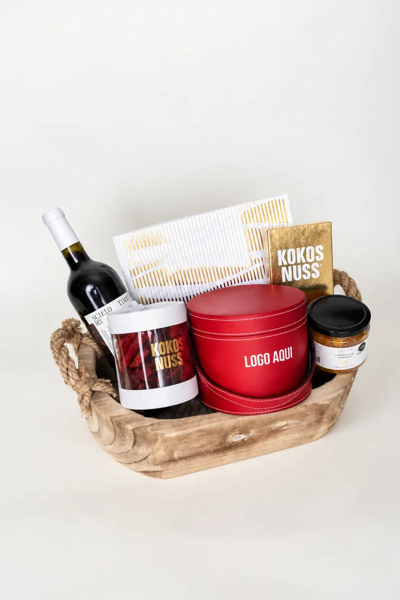 Canasta de madera con tambor rojo, vino y repostería